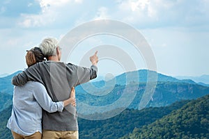 Asian Lifestyle senior couple hug and pointing the mountain nature.  Old people happy in love romantic and relax time.Â 